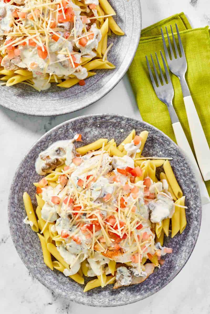 Copycat Johnny Carino's chicken penne gorgonzola on two plates.