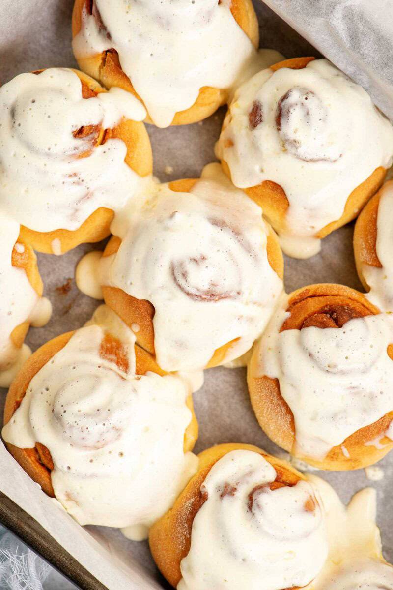 A pan of homemade cinnamon rolls with maple cream cheese frosting.