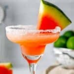 Homemade Olive Garden watermelon margarita garnished with a watermelon wedge.