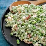 Pea salad with bacon and cheese on a plate.