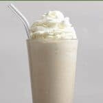 Homemade Chick-fil-A frosted coffee with a straw and coffee beans around it.