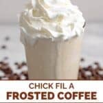 Homemade Chick-fil-A frosted coffee in a tall glass and coffee beans around it.