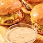 Copycat Sonic smasher sauce in a small bowl and burgers behind it.
