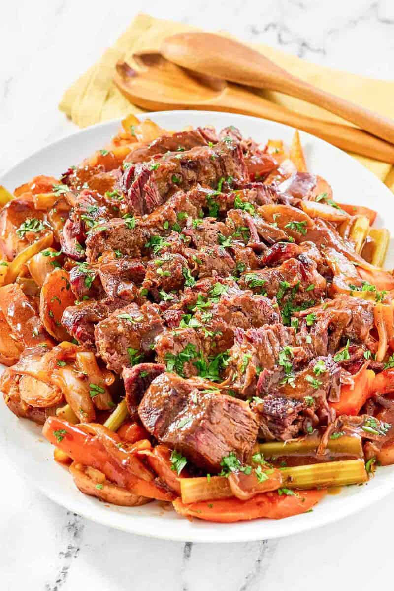 Copycat golden corral pot roast with vegetables and gravy on a platter.