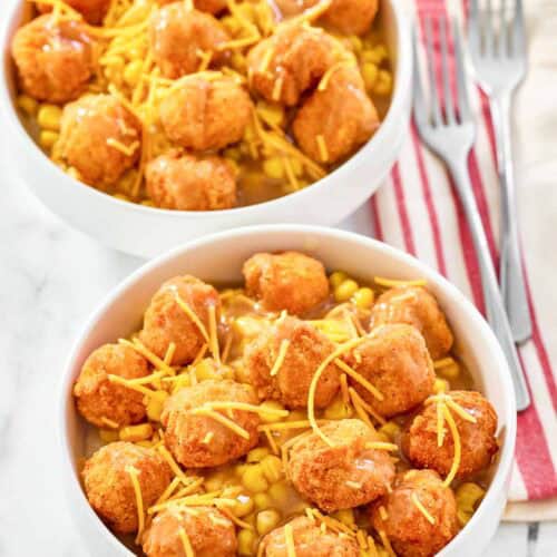 Two copycat KFC famous bowls and two forks on napkins.