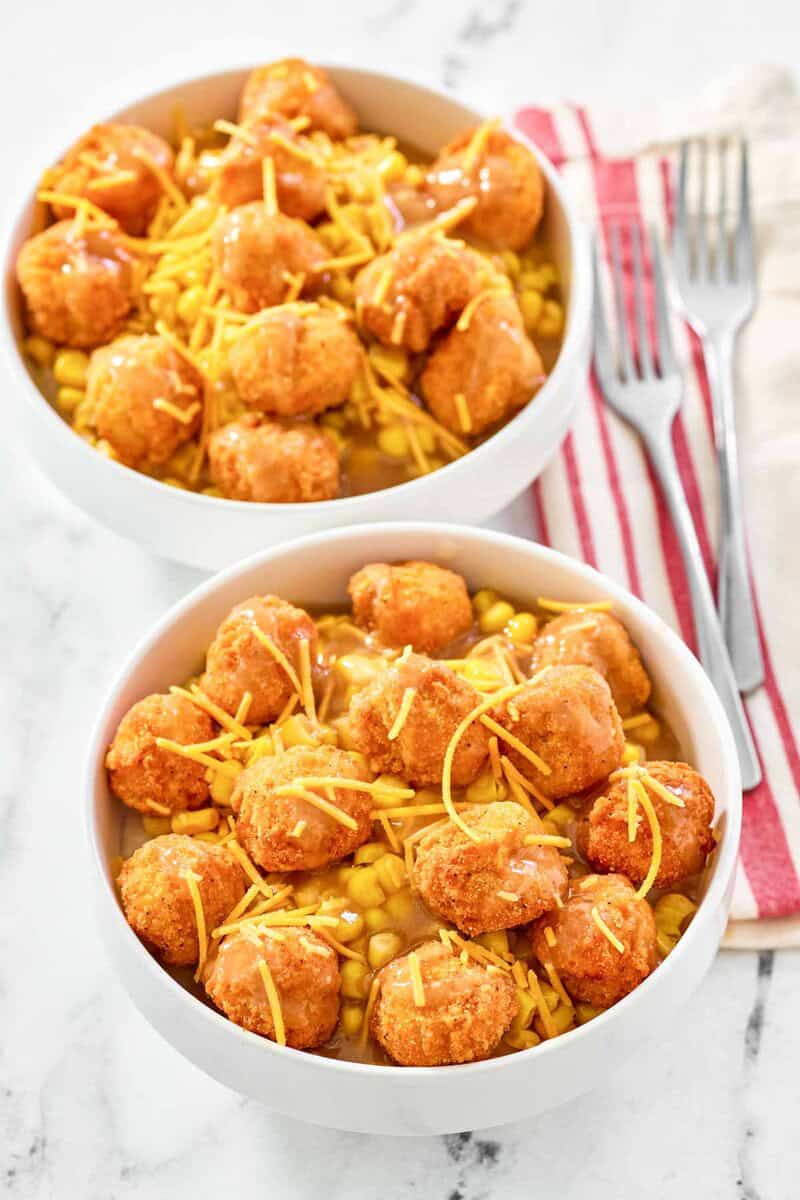 Two copycat KFC famous bowls and two forks on napkins.