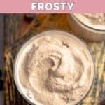 Homemade Wendy's chocolate frosting in a glass on top of a wood board.