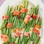 Bacon wrapped green bean bundles on an oval platter.