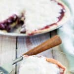 Copycat Marie Callender's sour cream blueberry pie and a slice on a glass plate.