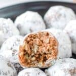 Homemade rum balls on a plate and one cut in half.