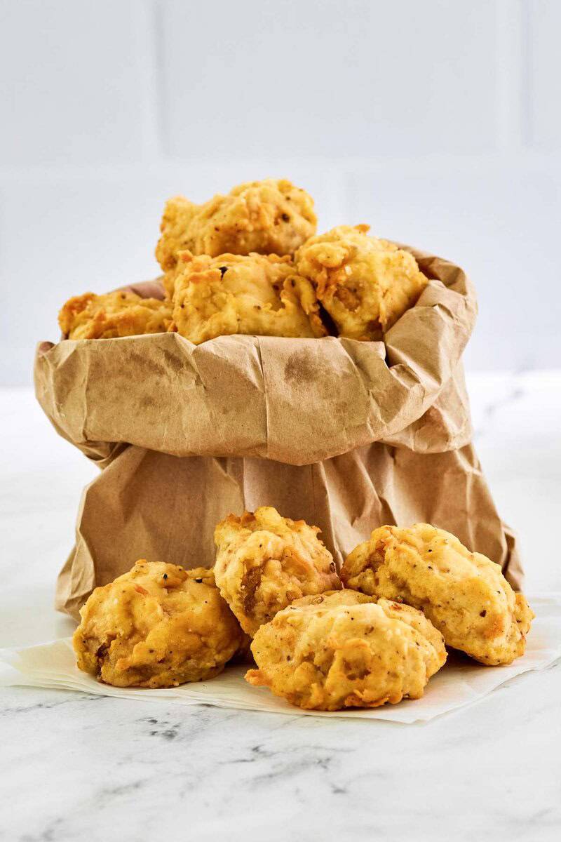 Copycat Fat Ronnie's deep fried mushrooms served in a small paper bag.