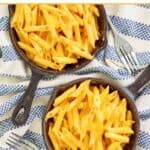 Homemade Outback Steakhouse mac and cheese in cast iron skillets and forks by them.