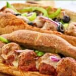 Homemade Subway meatball sub topped with onion, bell pepper, and olives.