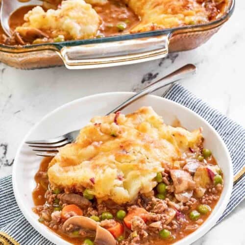 Copycat Cheesecake Factory shepherd's pie serving on a plate and the pie in a baking dish.