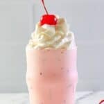 Copycat Chick-fil-A peppermint chip milkshake topped with whipped cream and a cherry.