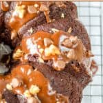 Homemade triple chocolate bundt cake drizzled with fudge sauce and sprinkled with chocolate chips and pecans.