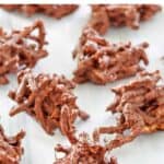 Several chocolate butterscotch haystacks on parchment paper.