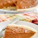 A slice of homemade chocolate cream pie on a plate and the pie behind it.