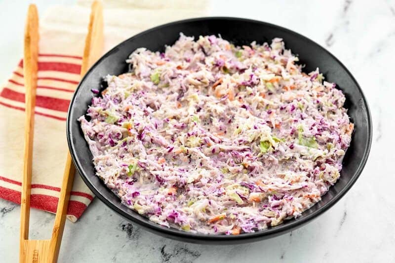A bowl of copycat Famous Dave's coleslaw on a marble surface.