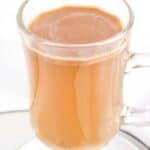 Homemade hot buttered rum cocktail in a glass mug on a coaster.