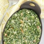 Homemade Lawry's creamed spinach in an oval cast iron baking dish.