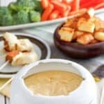 Copycat Melting Pot traditional Swiss fondue served with vegetables and bread.