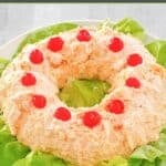 Orange fluff jello salad with maraschino cherries on top.