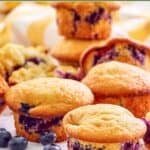 Homemade Otis Spunkmeyer blueberry muffins and fresh blueberries next to them.