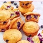 Homemade Otis Spunkmeyer blueberry muffins scattered on parchment paper.