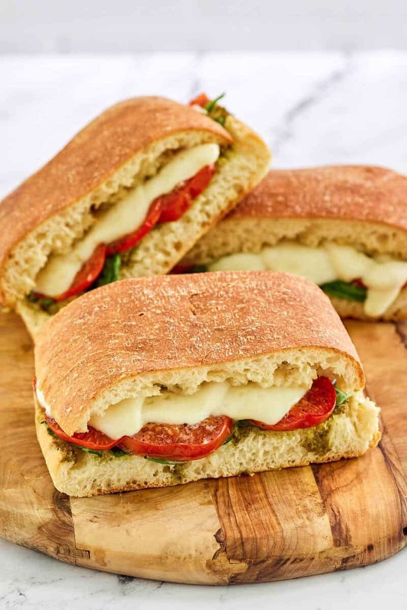 Copycat Starbucks tomato and mozzarella on focaccia sandwiches on a wooden board.