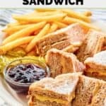 Slices of homemade Bennigan's monte cristo sandwich, jam, pickles, and fries.
