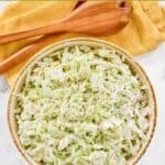 Homemade Brookville Hotel coleslaw in a serving bowl and wooden salad servers.