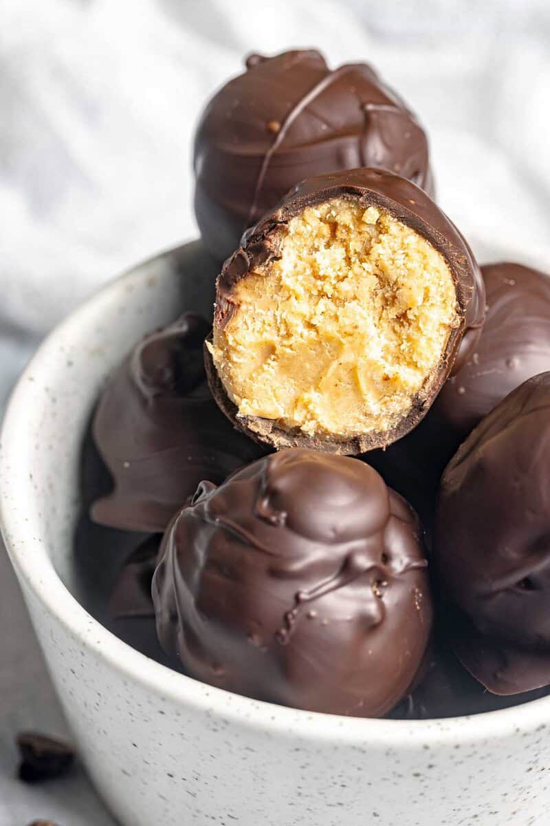 Homemade chocolate peanut butter balls in a small bowl.