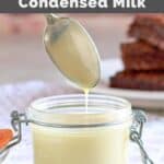 Homemade sweetened condensed milk in a glass jar on top of a cloth napkin.