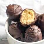Peanut butter balls covered in chocolate in a small bowl.