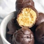 A bowl of homemade chocolate covered peanut butter balls.