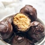 Chocolate covered peanut butter balls in a small bowl.