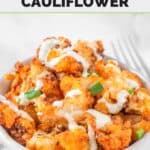 Air fryer buffalo cauliflower in a bowl with blue cheese dressing drizzled on top.