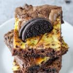 Homemade Oreo brownies stacked on a plate.