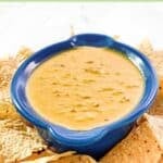 Spicy Rotel cheese dip and tortilla chips on a wooden platter.