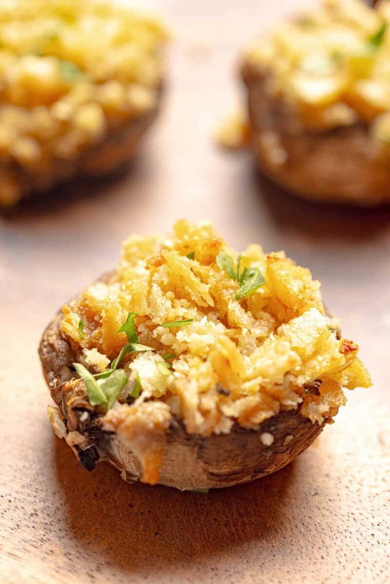 Stuffed mushrooms with Ritz crackers on a wood platter.