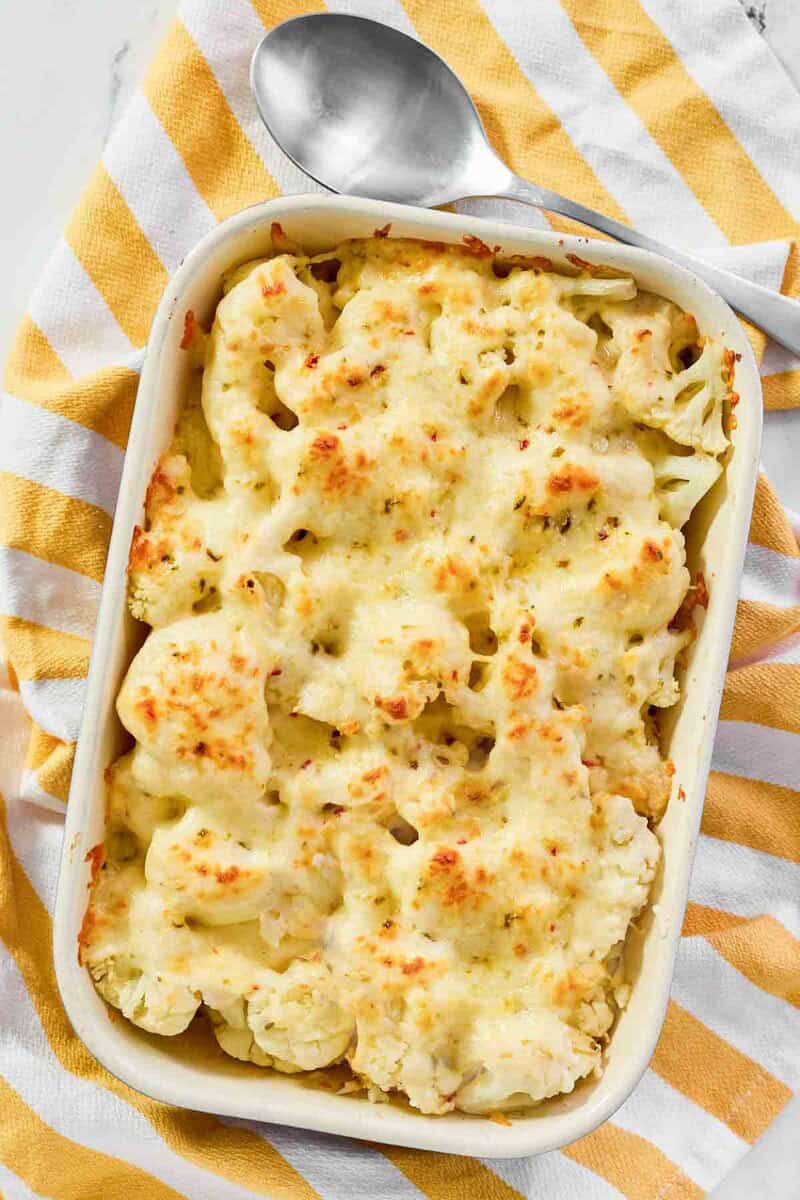 Overhead view of baked cauliflower with spicy cheese sauce.