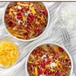 Bowls of Cincinnati chili topped with cheese, onions, and kidney beans.