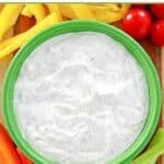 Homemade dill dip served with peppers, celery, carrots, and tomatoes.