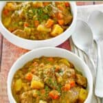 Beef stew with potatoes and carrots served in two bowls.