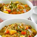 Thick and hearty beef stew served in two bowls.
