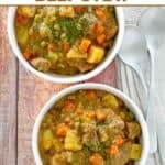 Hearty beef stew in two bowls and two spoons beside them.