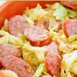 Closeup of fried cabbage, sausage, and bacon in a bowl.