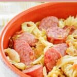Fried cabbage and sausage with bacon served in a bowl.