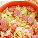 A bowl of southern fried cabbage and sausage with bacon.
